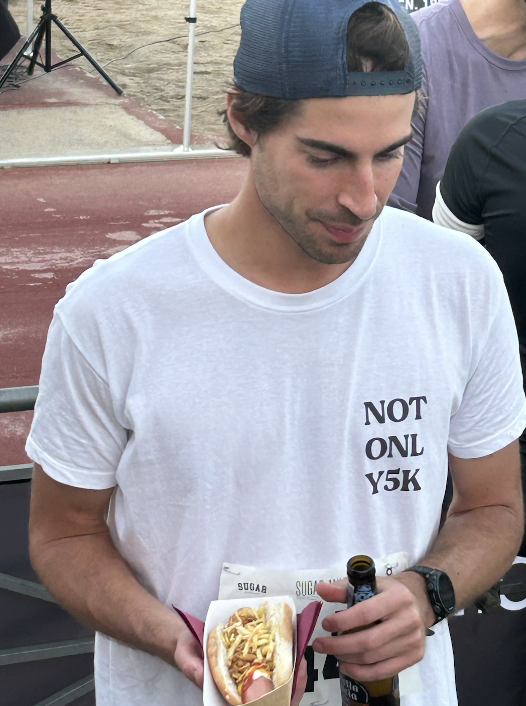 Invitado disfrutando de un hot dog recién preparado y bebida en el evento